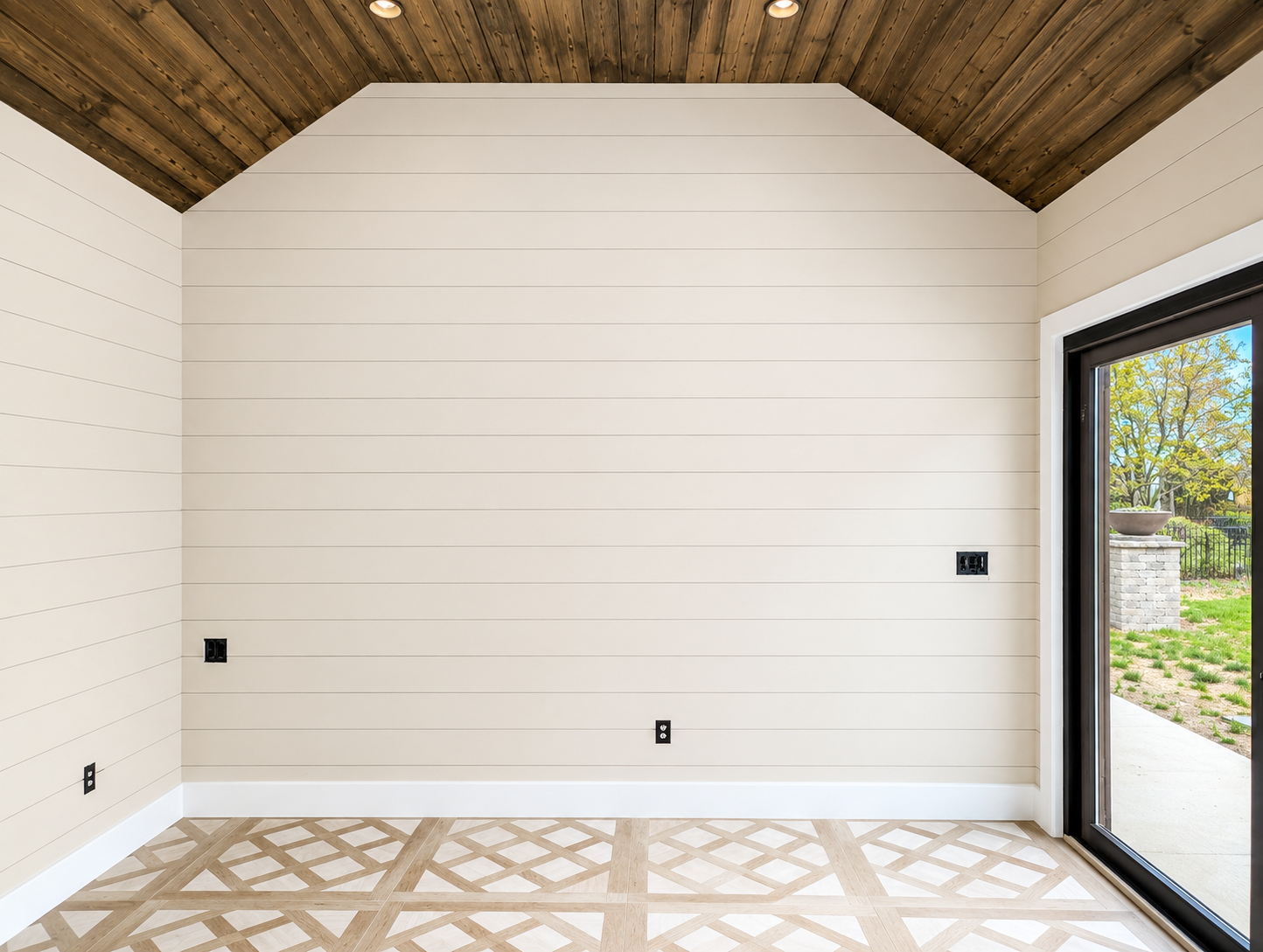 The same sunroom finished, with off-white shiplap walls, white baseboard and a stained wood vaulted ceiling